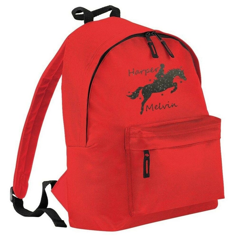 May include: A red backpack with black zippers, straps, and a handle. The front of the backpack features a black graphic of a horse and rider with the names "Harper Melvin" in script.