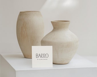 May include: Two beige ceramic vases on a white surface with a white card that reads "BARRO BY ALUBIA DESIGN".