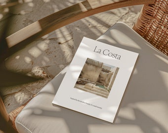 May include: A white brochure with the text "La Costa" and a photo of a courtyard with a pool. The text below the photo reads "Inspired by the timeless beauty of coastal serenity."