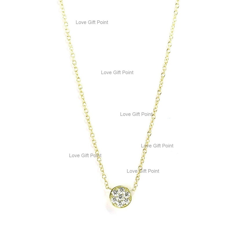 May include: A delicate gold chain necklace with a small round pendant set with sparkling white cubic zirconia stones.