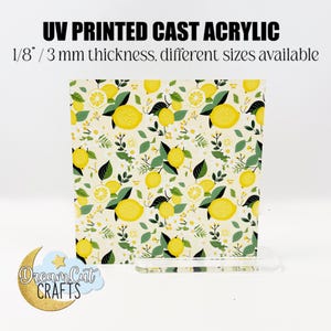 Könnte beinhalten: Ein quadratisches Stück UV-bedrucktes Acryl-Guss mit einer Dicke von 3 mm und einem Zitronen- und Blumenmuster. Das Acryl steht auf einem klaren Acryl-Ständer.
