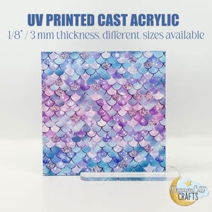 Könnte beinhalten: Eine 3 mm dicke UV-bedruckte Acrylglasplatte mit einem Meerjungfrauen-Schuppenmuster in Blautönen, Lila und Weiß. Die Schuppen haben eine glitzernde Oberfläche.