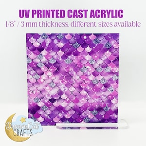 Könnte beinhalten: Eine 3 mm dicke, transparente Acrylglasplatte mit einem bedruckten Design aus violetten und silbernen Meerjungfrauen-Schuppen. Die Acrylglasplatte steht auf einem transparenten Acryl-Ständer. Der Text "UV PRINTED CAST ACRYLIC" und "1/8"/3 mm thickness, different sizes available" ist oben im Bild gedruckt. Der Text "Dream Cut CRAFTS" ist unten im Bild gedruckt.