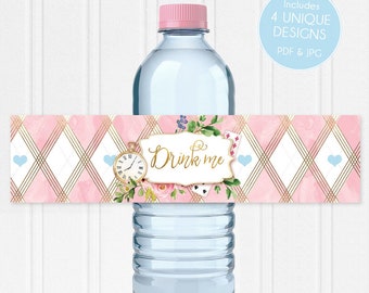 Könnte beinhalten: Rosa-goldenes Wasserflaschenetikett mit weißem Hintergrund. Das Etikett zeigt ein florales Design mit einer Taschenuhr, Spielkarten und dem Text "Drink me".