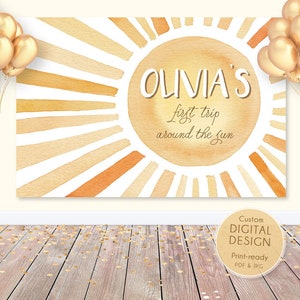 May include: A watercolor illustration of a sun with the text "OLIVIA'S first trip around the sun" on a white background. The sun is painted in shades of yellow and orange.