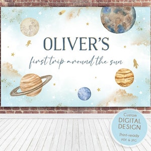 May include: A blue and gold space-themed banner with the text "OLIVER'S first trip around the sun". The banner features planets, stars, and a rocket.