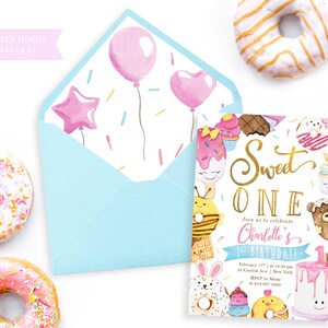 May include: A pink and blue invitation with a gold glitter design for a first birthday party. The invitation features a donut, cupcake, ice cream cone, and a cake with the words "Sweet One" and "Join us to celebrate Charlotte's 1st Birthday!"