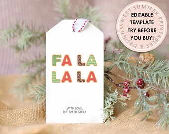 Peut inclure: Une étiquette cadeau blanche avec le texte "FA LA LA LA" en lettres rouges, vertes et brunes. Les lettres sont décorées pour ressembler à des biscuits en pain d'épices. L'étiquette comprend également le texte "WITH LOVE. THE SMITH FAMILY".