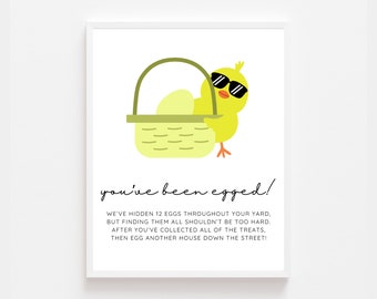Peut inclure: Un poussin jaune portant des lunettes de soleil tient un panier rempli d'œufs jaunes. Le texte dit "you've been egged!"  We've hidden 12 eggs throughout your yard, but finding them all shouldn't be too hard. After you've collected all of the treats, then egg another house down the street!