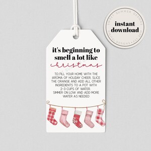 May include: Printable gift tag featuring a red and white striped stocking design. The tag reads "it's beginning to smell a lot like Christmas" and includes instructions for making a simmer pot with orange slices and other ingredients.