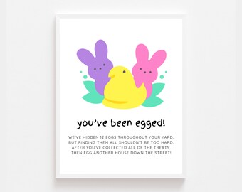 Peut inclure: Une affiche imprimable avec une illustration de lapin en guimauve jaune, rose et violet. Le texte dit "you've been egged!" et comprend des instructions pour une chasse aux œufs de Pâques amusante.