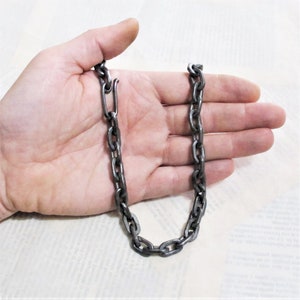 Pu&ograve; includere: Una collana a catena argentata con chiusura. La catena &egrave; composta da maglie spesse di forma ovale.