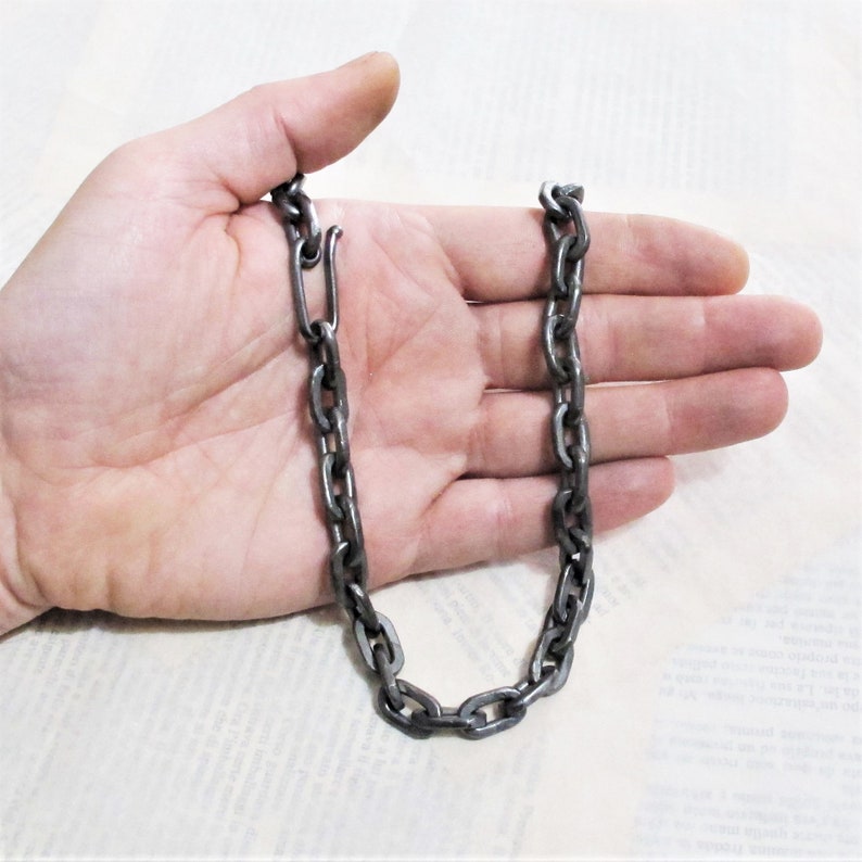 Pu&ograve; includere: Una collana a catena argentata con chiusura. La catena &egrave; composta da maglie spesse di forma ovale.