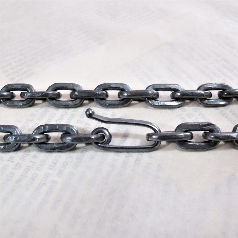 Pu&ograve; includere: Una collana a catena in metallo nero spessa con una semplice chiusura a gancio.