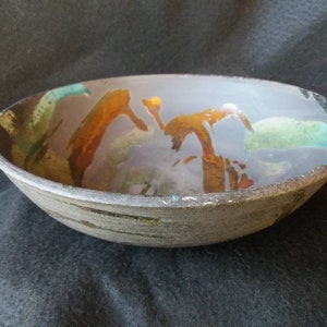 May include: A ceramic bowl with a grey glaze and abstract brown, orange, and green designs.