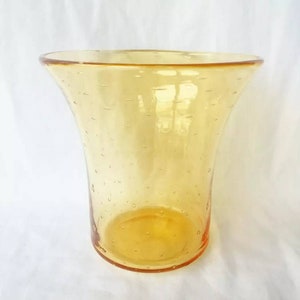 May include: A clear amber glass vase with a textured bubbled surface. The vase has a wide mouth and a narrow base.