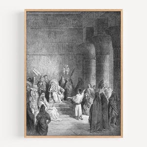 May include: Black and white framed print of a historical scene depicting a gathering of people in an ancient setting. The artwork features detailed illustrations of figures in robes and headdresses, with architectural elements like columns and walls.