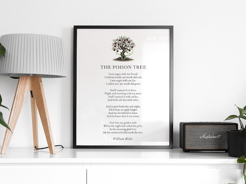 May include: A framed print of William Blake's poem "The Poison Tree" with a tree illustration. The black framed print is displayed on a white shelf with a lamp and speaker.