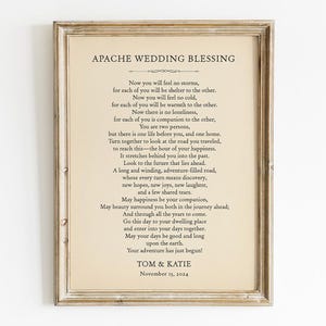May include: A framed print of the "Apache Wedding Blessing" poem, with black text on a cream background. The frame is a distressed, light brown colour. The names "Tom & Katie" and the date "November 13, 2024" are at the bottom of the print.