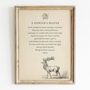 May include: Framed print featuring "A Hunter's Prayer" with a deer illustration. The text is in a classic font on a cream-colored background, framed in a rustic, light-brown wooden frame. The artwork includes a leaf and deer illustration.