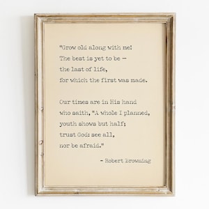 Może przedstawiać: Oprawiony wydruk o estetyce vintage. Grafika zawiera cytat Roberta Browninga czarnym tekstem na kremowym tle. Rama jest w kolorze postarzanego, jasnobrązowego, co dodaje rustykalnego uroku.