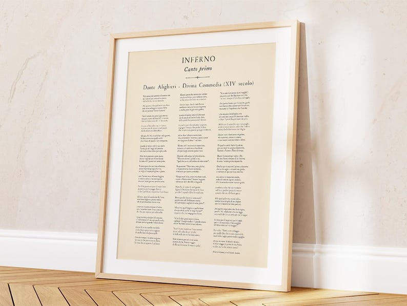 May include: A framed print of a page from Dante Alighieri's Inferno, Canto Primo. The text is in Italian, printed on aged paper, and set within a light wood frame. The print is leaning against a wall and floor.