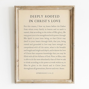 Puede incluir: Impresión enmarcada con el texto "DEEPLY ROOTED IN CHRIST'S LOVE" en estilo vintage. El texto es un pasaje de Efesios 3:14-21, impreso sobre un fondo crema, enmarcado en un marco de madera marrón claro envejecido.