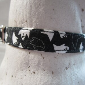 Puede incluir: Collar de perro blanco y negro con un patr&oacute;n de fantasmas.