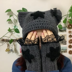 May include: Gray crocheted hat with black star embellishments and matching fingerless gloves with black lace trim.