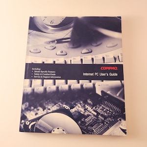 May include: A Compaq Internet PC User's Guide manual with a dark blue and white cover. The cover features a graphic collage of a computer keyboard, a clock, and a hard drive circuit board. Text includes "Including: Model-Specific Features, Safety & Comfort Guide, Service & Support Information."
