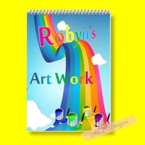 May include: A colourful rainbow design on a spiral bound notebook with the text "Robyn's Art Work" and paint cans at the bottom.