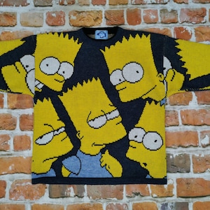 Könnte beinhalten: Ein gelber und blauer Strickpullover mit mehreren Bildern des Simpsons-Charakters Bart Simpson.