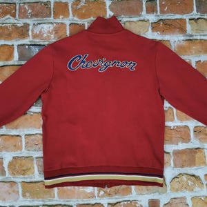 Cárdigan vintage Chevignon 1957, rojo con letras cursivas, estilo casual, etiqueta Legend.