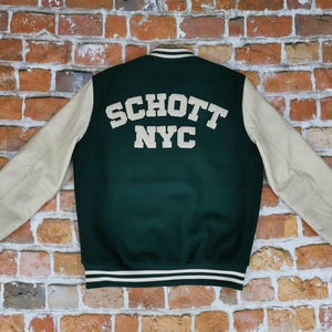 May include: A green and cream varsity jacket with the text "SCHOTT NYC" on the back.