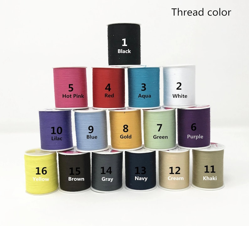May include: A collection of 16 spools of thread in various colors, numbered 1 through 16. The thread colors include black, hot pink, red, aqua, white, lilac, blue, gold, green, purple, yellow, brown, gray, navy, cream, and khaki.