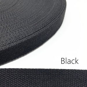 May include: Black cotton webbing, a close-up of the woven texture.  The webbing is rolled up in the top image and laid flat in the bottom image.  Black.