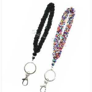 May include: Two beaded keychains, one black and one with multicolored beads. Both keychains have a silver ring and a silver clip.