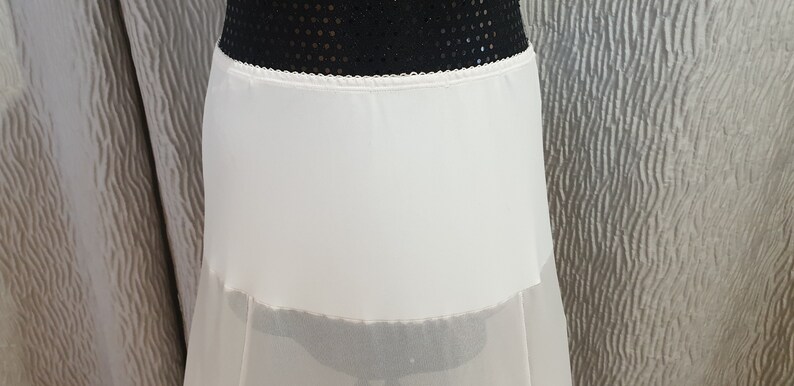 Puede incluir: Una enagua de tul blanco con una cinturilla de sat&eacute;n. La falda es de capas y tiene un aspecto transparente y fluido.