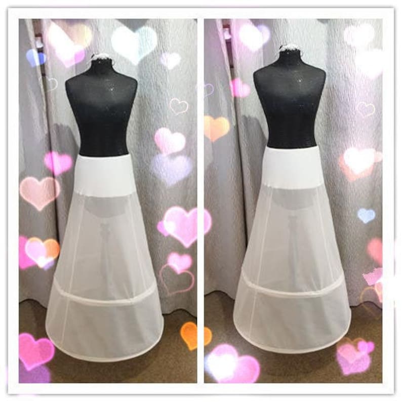 Puede incluir: Enaguas de tul blanco con tres capas y una cinturilla de sat&eacute;n blanco. La enagua se muestra en un maniqu&iacute; sobre un fondo de corazones rosas y blancos.