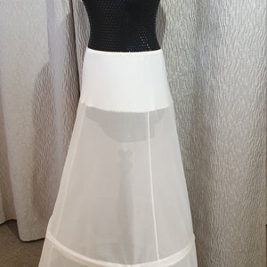 Puede incluir: Un enagua de tul blanco con una cinturilla de sat&eacute;n. La enagua tiene tres capas de tul y est&aacute; dise&ntilde;ada para a&ntilde;adir volumen a una falda o vestido.