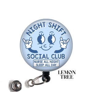 May include: Blue and white badge reel with a cartoon face and the text "Night Shift Social Club Nurse All Night Sleep All Day". The badge reel is attached to a black retractable cord and a silver clip.