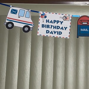 May include: A festive banner with a postal theme, featuring white mail trucks and signs that read "Happy Birthday David." The banner also includes a mailbox cutout. The design incorporates red, white, and blue colors, perfect for a birthday celebration.