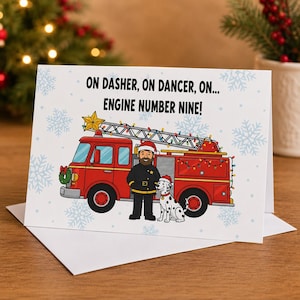 May include: A white greeting card featuring a red fire truck with a ladder, a firefighter in a Santa hat, and a Dalmatian dog. The text reads: ON DASHER, ON DANCER, ON... ENGINE NUMBER NINE! The background is decorated with light blue snowflakes.