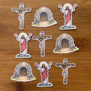 May include: A collection of nine die-cut stickers featuring religious illustrations. The designs include Jesus on a wooden cross with a sign reading Jesus, a stone tomb entrance, and Jesus standing with arms raised wearing a red and white robe.