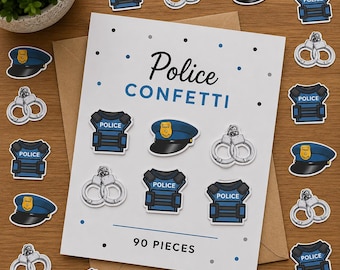 May include: A white card with the text Police CONFETTI and 90 PIECES, surrounded by scattered paper cutouts of blue police vests, blue police hats with gold badges, and silver handcuffs, all arranged on a brown wooden surface.