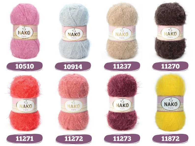 Op de afbeelding: Een verzameling van acht bollen Nako Paris garen in diverse kleuren, waaronder roze, blauw, beige, bruin, rood, koraal, bordeaux en geel. Elke bol heeft een label met de merknaam en een uniek nummer. Het garen ziet er zacht en pluizig uit.