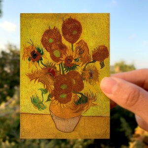 May include: A painting of a vase filled with yellow sunflowers. The sunflowers are painted in a vibrant yellow with hints of orange and brown. The vase is a simple brown ceramic.