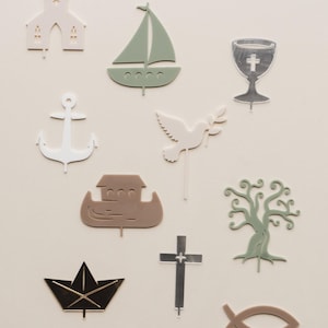Könnte beinhalten: Ein Set mit 10 Acryl-Kuchen-Toppern mit religiösen Symbolen, darunter eine Kirche, ein Segelboot, ein Kelch, ein Anker, eine Taube, ein Boot, ein Baum, ein Kreuz, ein Papierboot und ein Fisch.
