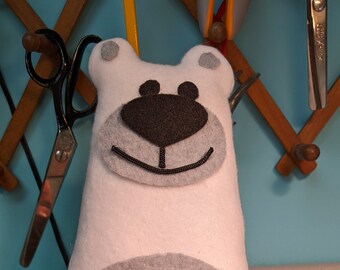 May include: A white plush bear with a gray nose and a gray circle on its belly is sitting in the back of a red toy pickup truck.