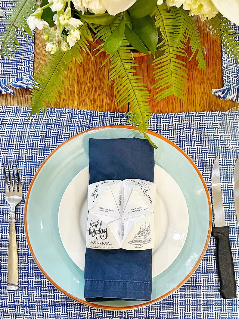 Paper fortune teller on blue napkin and blue plate